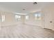 Bright living room with light wood floors, large windows, and a white door at 9712 Rocket Grove Ct, Las Vegas, NV 89178