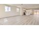 Bright, open-concept living room with light wood floors, large windows, and a view into the modern kitchen at 9712 Rocket Grove Ct, Las Vegas, NV 89178