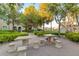 Inviting outdoor common area with stone tables, seating, mature trees and beautifully maintained landscaping at 9975 Peace Way # 1024, Las Vegas, NV 89147