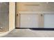 Attached two-car garage with classic paneled doors and exterior lighting at 9975 Peace Way # 1024, Las Vegas, NV 89147