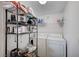 A laundry area features a washer and dryer, wire shelving, storage space, and overhead lighting at 9975 Peace Way # 1024, Las Vegas, NV 89147