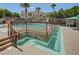 Inviting community pool with a baja shelf, lush landscaping, and a nearby gazebo at 9975 Peace Way # 1024, Las Vegas, NV 89147