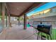 View of the back patio with a covered area, a spa and a grassy area with a grill at 1011 Pecos River Ave, Henderson, NV 89002