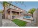 Backyard features a pool and spa, covered patio, grassy area and a fence at 1011 Pecos River Ave, Henderson, NV 89002