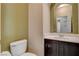 Charming powder room featuring dark vanity, marbled countertop, and a decorative arched mirror at 1011 Pecos River Ave, Henderson, NV 89002