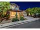 Charming home with a well-manicured lawn, stone accents, and a welcoming entrance at twilight at 1011 Pecos River Ave, Henderson, NV 89002