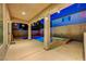 Inviting outdoor area with a pool and spa under a covered patio, illuminated by string lights at dusk at 1011 Pecos River Ave, Henderson, NV 89002