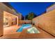 Tranquil backyard featuring a pool, spa, and covered patio, lit with string lights for evening ambiance at 1011 Pecos River Ave, Henderson, NV 89002