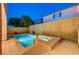 Twilight view of a serene backyard pool and spa, nestled within a private, fenced garden at 1011 Pecos River Ave, Henderson, NV 89002