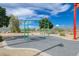 Green swingset sits on a grey rubber-filled pad, surrounded by desert landscaping and a blue sky at 1011 Pecos River Ave, Henderson, NV 89002