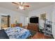 Bright bedroom featuring hardwood floors, a ceiling fan, and large TV at 10205 Camborne Ave # 104, Las Vegas, NV 89144