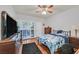 Comfortable bedroom with hardwood floors, modern ceiling fan, and large TV at 10205 Camborne Ave # 104, Las Vegas, NV 89144