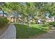 Community park with mature trees, manicured lawn and sidewalk at 10205 Camborne Ave # 104, Las Vegas, NV 89144