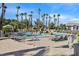 Resort-style community pool featuring a rock waterfall and ample lounge seating at 10205 Camborne Ave # 104, Las Vegas, NV 89144