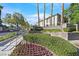 Landscaped entrance to Carlisle community with flowering bushes and mature trees at 10205 Camborne Ave # 104, Las Vegas, NV 89144