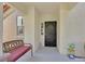 Inviting entryway featuring a comfortable bench, a secure black door, and decorative lawn ornaments at 10205 Camborne Ave # 104, Las Vegas, NV 89144