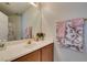 Bathroom featuring a vanity with wood cabinets, a large mirror and decorative floral-themed towels at 10952 Porto Foxi St, Las Vegas, NV 89141