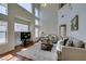 Bright living room features high ceilings, large windows, and comfortable seating arrangement at 10952 Porto Foxi St, Las Vegas, NV 89141