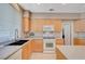 Well-lit kitchen features light wood cabinets, modern appliances, double sink, and island countertop at 1316 Borderwood Ln, North Las Vegas, NV 89031