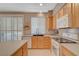 Bright kitchen with light wood cabinetry, gas range, island with countertops, and a modern sink at 1316 Borderwood Ln, North Las Vegas, NV 89031