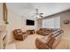 Cozy living room features a fireplace, a ceiling fan, and comfortable brown leather seating at 1316 Borderwood Ln, North Las Vegas, NV 89031