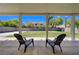 Relaxing covered patio with two chairs overlooks a spacious backyard with green grass at 1316 Borderwood Ln, North Las Vegas, NV 89031