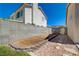Narrow side yard with a gravel bed is bordered by block wall fencing at 1316 Borderwood Ln, North Las Vegas, NV 89031