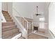 Bright entryway with staircase, white railing, and ceramic tile flooring leads to the living space with a fireplace at 1663 Cloister Ave, Henderson, NV 89014
