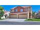 Inviting two-story home features a terracotta roof, tan stucco, and a two-car garage, set against a clear blue sky at 1663 Cloister Ave, Henderson, NV 89014