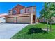 Beautiful home featuring a terracotta roof and two-car garage, complemented by green lawn and vibrant landscaping at 1663 Cloister Ave, Henderson, NV 89014