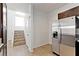 Kitchen area with modern stainless steel refrigerator and staircase access at 1663 Cloister Ave, Henderson, NV 89014