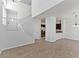 Open-concept living space with staircase, showcasing tiled flooring, a fireplace, and a glimpse of the modern kitchen at 1663 Cloister Ave, Henderson, NV 89014