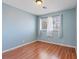 Light blue bedroom with wood-look flooring and a bright window at 1711 Ember Glow Cir, Las Vegas, NV 89119