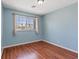 Light blue bedroom with wood-look flooring and a bright window view at 1711 Ember Glow Cir, Las Vegas, NV 89119