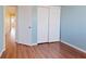 Light blue bedroom with wood-look flooring and closet with sliding doors at 1711 Ember Glow Cir, Las Vegas, NV 89119