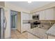 Cozy kitchen features white cabinetry, granite countertops and stainless steel appliances at 1711 Ember Glow Cir, Las Vegas, NV 89119
