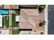 Aerial top-down view of a backyard showing faux grass, patio, fire pit, and nearby pool within a housing community at 2024 Mystic Wave Rd, North Las Vegas, NV 89031