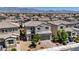 Aerial view showcasing a residential area with well-kept houses, tile roofs, and neatly landscaped yards, plus mountain backdrop at 2024 Mystic Wave Rd, North Las Vegas, NV 89031