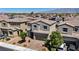 Aerial shot of a neighborhood showcasing well-maintained homes with tile roofs and desert landscaping, with mountain views at 2024 Mystic Wave Rd, North Las Vegas, NV 89031