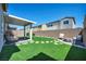Lush backyard with artificial turf, covered patio, privacy wall, and fire pit at 2024 Mystic Wave Rd, North Las Vegas, NV 89031