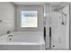 Clean bathroom featuring a large soaking tub and a glass-enclosed shower at 2024 Mystic Wave Rd, North Las Vegas, NV 89031