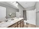 Bathroom with double sink vanity, a large mirror, and tub with shower at 2024 Mystic Wave Rd, North Las Vegas, NV 89031
