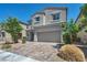 Charming two-story home with a two-car garage, desert landscaping, and a brick driveway at 2024 Mystic Wave Rd, North Las Vegas, NV 89031