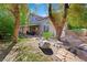 Expansive backyard featuring lush greenery, mature trees, and a covered patio perfect for outdoor living at 2229 Armacost Dr, Henderson, NV 89074