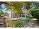 Serene backyard featuring mature trees, lush grass, and a covered patio area perfect for entertaining at 2229 Armacost Dr, Henderson, NV 89074