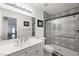 Modern bathroom with black and white patterned shower tiles, a large mirror, and white cabinets at 2229 Armacost Dr, Henderson, NV 89074