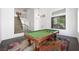Bright living area featuring a billiard table and a view of the staircase leading to the second floor at 2229 Armacost Dr, Henderson, NV 89074