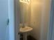Cozy half-bath features a pedestal sink, and a modern mirror at 2406 Pebble Springs Ct, Henderson, NV 89074