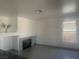 Open-concept living room with fireplace, tile flooring, and natural light at 2406 Pebble Springs Ct, Henderson, NV 89074