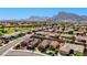 Expansive aerial view of a desert community with well-maintained homes, lush lawns, and stunning mountain backdrop at 2605 Orchid Valley Dr, Las Vegas, NV 89134